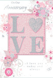 The photograph shows a romantic anniversary card whose design blends soft colour and tactile detail with the calm elegance of Clerkenwell's quiet lanes. Dominating the centre is the word LOVE, spelled out in raised, block capitals that are generously coated with fine, sparkling glitter. The glitter appears in a pale, silvery-pink tone, giving each letter a frosted glow that seems to shift with the light, hinting at both warmth and delicacy. This central word rests upon a slightly lighter blush-pink panel, set within a broader field of powder pink that stretches to the edges of the card, creating a gentle, monochrome harmony. Around the main motif, delicate blooms and trailing vines have been illustrated in a style reminiscent of a florist sketching ideas for an anniversary bouquet. Each flower is composed of refined, almost feathery petals in blush, pearly white, and pale grey, with silver accents that glint subtly along petal edges and leaf veins. The swirling lines of stems and foliage curl gracefully, framing the word LOVE without overwhelming it, much like foliage framing feature flowers in a hand-tied arrangement from a local Clerkenwell florist. Scattered flourishes and fine scrolls add a sense of movement, as if a light breeze has passed over the design. An anniversary message, set in a flowing, elegant script, sits comfortably alongside the artwork, balancing the textured letters with handwritten warmth. Altogether, the card conveys a feeling of enduring romance-soft, sincere, and beautifully composed, like a pastel bouquet chosen to celebrate a shared life in this historic London neighbourhood.